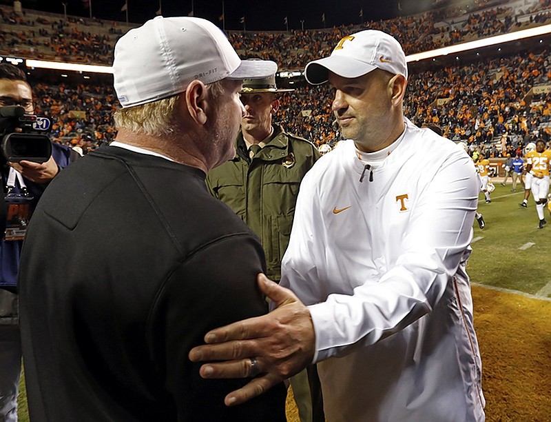 Tennessee football coach Jeremy Pruitt, right, shakes hands with Kentucky coach Mark Stoops after Pruitt's Vols beat the Wildcats 24-7 Saturday in Knoxville.