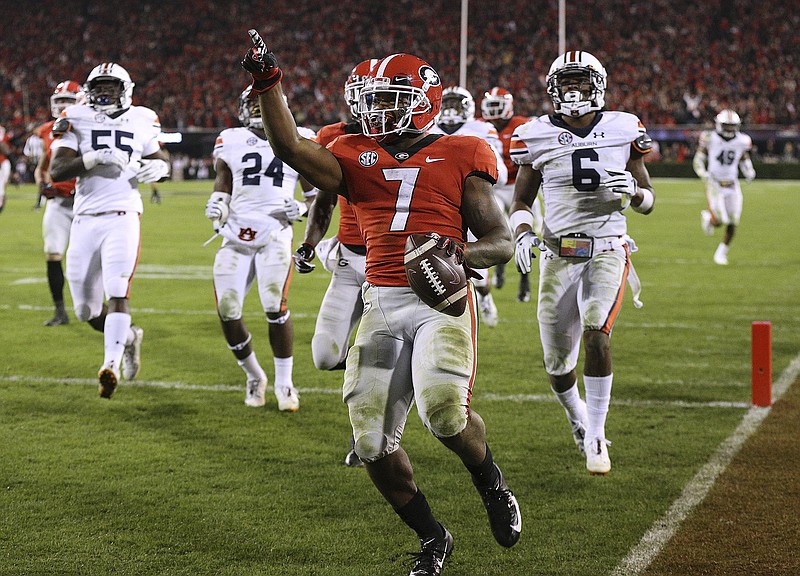 Georgia tailback D'Andre Swift points to fans in the end zone after breaking away from Auburn defenders for a long touchdown run during the fourth quarter of the Bulldogs' victory Saturday night. Swift reset his single-game collegiate record for rushing yards with 186 just a week after totaling 156 against Kentucky.