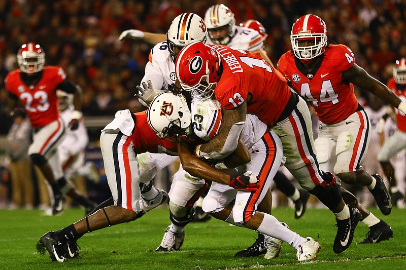 Georgia defensive end Jonathan Ledbetter (13) tackles Auburn receiver Ryan Davis (23) after a short gain Saturday night during the 27-10 win by the Bulldogs in Athens.