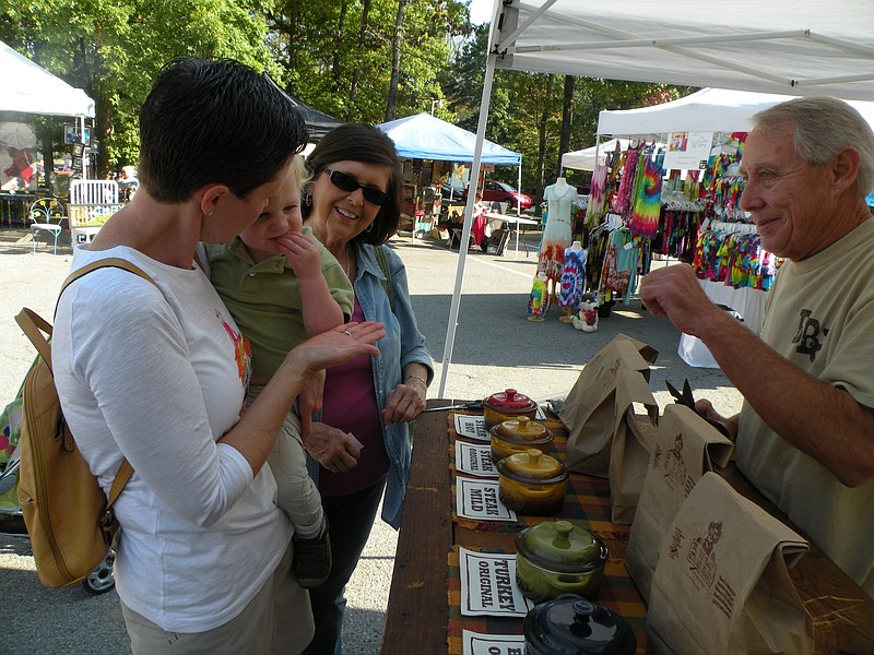 Shoppers get samples from a vendor at a previous year's Hodgepodge held in the parking lot of the Signal Mountain Town Hall complex.