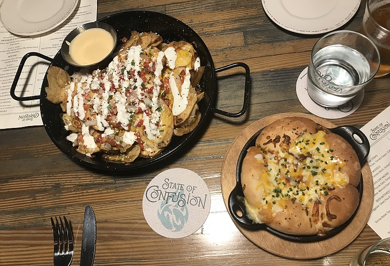 Two starters, Potato Chip Nachos and Savory Monkey Bread, are served in cast-iron skillets. The nachos feature a light dusting of toppings that could be more evenly distributed, complemented with an excellent cheese dip.