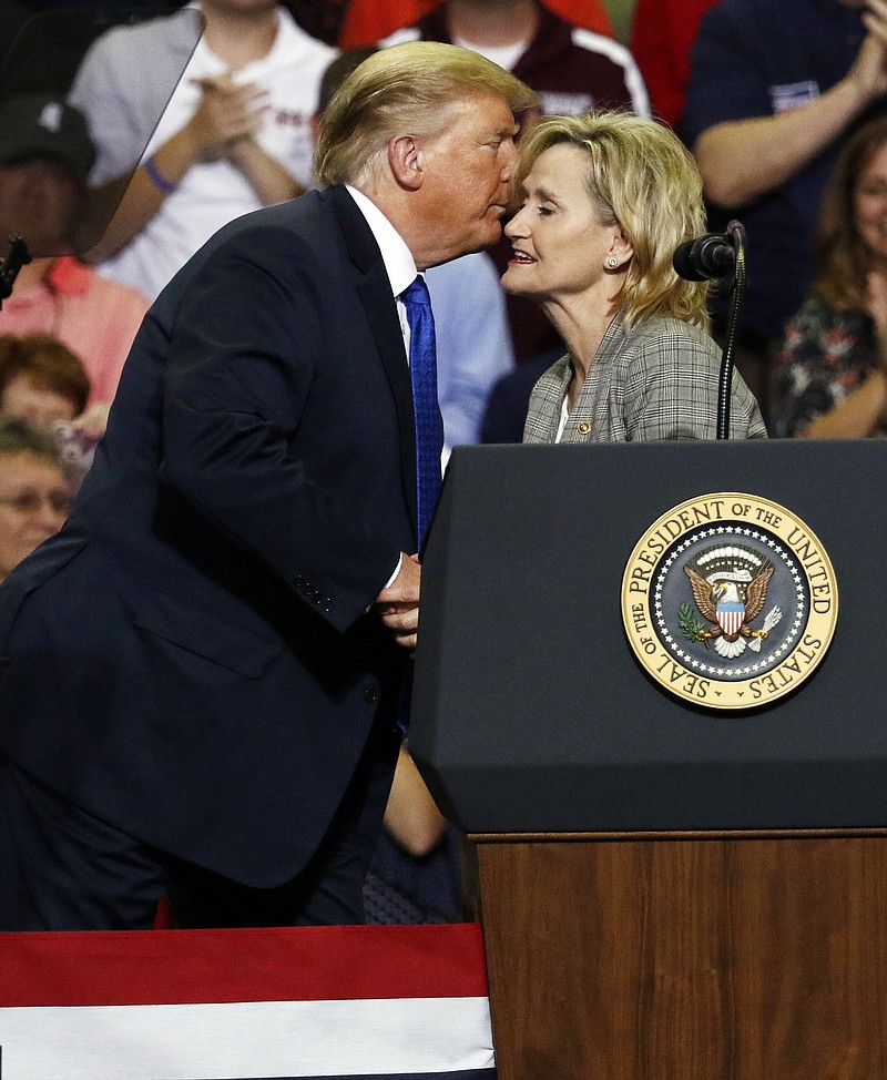 President Donald Trump kisses Sen. Cindy Hyde-Smith, R-Miss., after introducing her at an October campaign rally in Southaven, Miss. (AP Photo/Rogelio V. Solis)