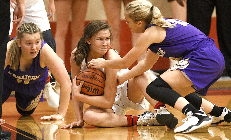 Signal Mountain's Janie Kennedy tries to secure a loose ball in between two Sequatchie County defenders during Thursday night's high school basketball game at Signal Mountain. The host Lady Eagles won 47-37.
