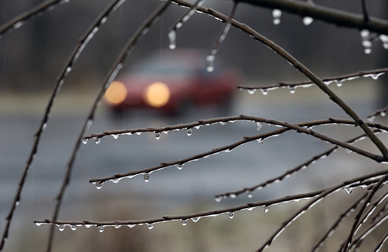 A car drives slowly in the rain on an icy rural road near Newtown, Pa., in this Sunday, Jan. 18, 2015, file photo. (AP Photo/Mel Evans)