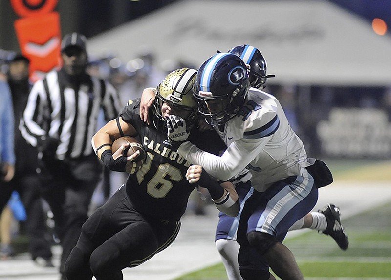 Calhoun's Collin Baggett gets tackled by Lovett's McLeod Buckham-White during Friday night's state playoff game in Calhoun, Ga. The host Yellow Jackets won the GHSA Class AAA second-round matchup 21-6.