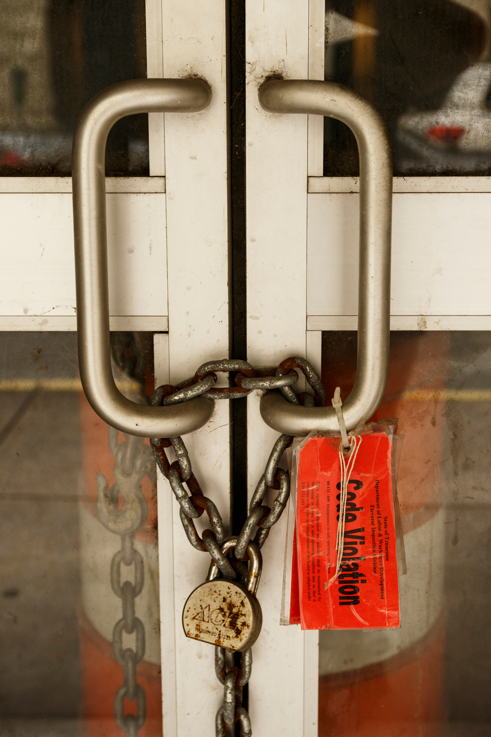 Code violation tags hang on the doors of a vacant storefront on West 8th Street on Tuesday, Oct. 2, 2018, in Chattanooga, Tenn.