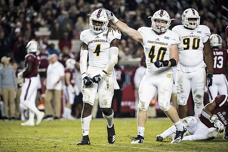 UTC linebacker Tavon Lawson (4) and Marshall Cooper (40) celebrate a defensive play during the first half of Saturday night's game at South Carolina.