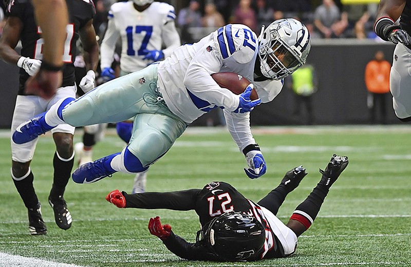 Dallas Cowboys running back Ezekiel Elliott gets upended by Atlanta Falcons strong safety Damontae Kazee during the first half of Sunday's game in Atlanta.