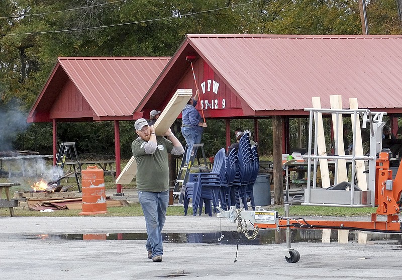 Adam Driggers, of Home Depot's Decatur, Ala., store, works to replace the wood fence on the east side of the post's property. Volunteers also repaired and expanded an awning at the front of the building.