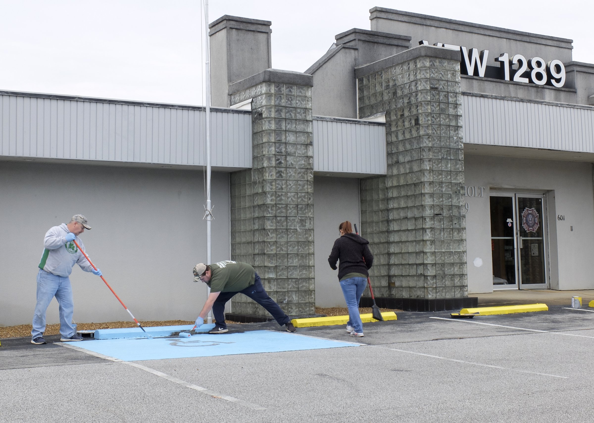 Fort Oglethorpe, Ga., store employees Mike O'Neal, Matthew Gardner and Brenda Hernandez paint the parking zone in front of the building. In addition to exterior painting, volunteers also did general landscaping.