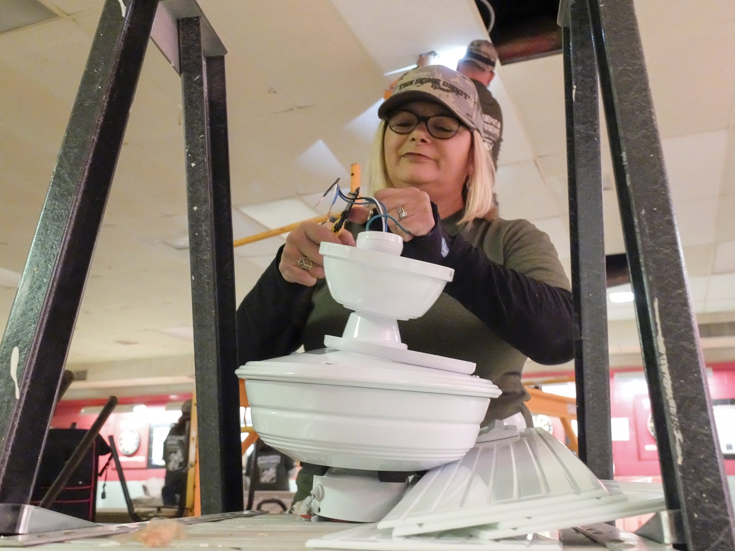 Thirty-year Home Depot employee Wendy Gilstrap assembles one of eight new ceiling fans to be installed at the post. In addition to creating curb appeal, the goal was to create a nice environment inside to revitalize the post, in turn increasing membership and raising revenues to allow for a more self-sustained maintenance and upkeep process.