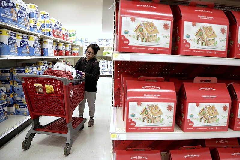 In this Friday, Nov. 16, 2018, photo, a shopper looks at an item before placing it in her cart during a trip to a Target store in Edison, N.J. Shoppers are spending freely heading into the holidays, but heavy investments and incentives like free shipping by retailers are giving Wall Street pause. Target Inc., Kohl's Corp., Best Buy Co. and TJX Cos. all reported strong sales at stores opened at least a year. (AP Photo/Julio Cortez)