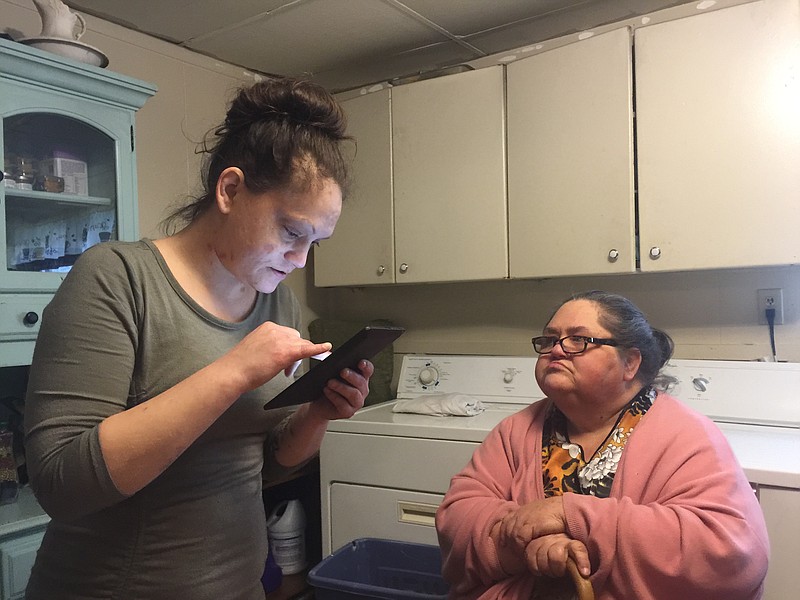 Staff photo by Tyler Jett / Frances Estes, left, looks at pictures of her nephew, Christopher Colby Estes, on her tablet as Sheila Estes sits in her kitchen on Lee Avenue in Rossville. Christopher Estes died in June 2017 after his best friend, Matthew Joel Durham, accidentally shot him with a gun he thought was empty.