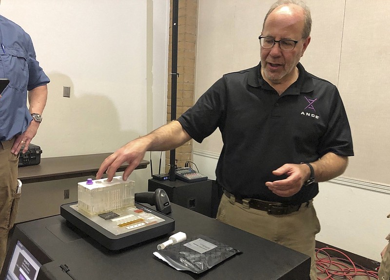 In this photo taken November 16, 2018, Stephen Meer, chief information officer from ANDE, demonstrates in Chico, Calif., his company's Rapid DNA analysis system, which is being used to try to ID victims of the Northern California wildfire. Authorities have deployed a powerful tool to aid in their race to identify the remains of 77 bodies burned in the deadly wildfire that ripped through Northern California: Rapid DNA testing that produces results in just two hours. But the technology that can match DNA to bone fragments in as little as two hours is only as effective as the numbers of people who show up to give a sample, and so far there are not nearly enough volunteers. (Sudhin Thanawala)

