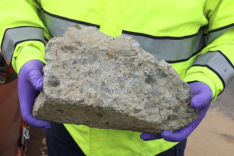In this photo released by the Nashville Police, an officer holds large piece of concrete that struck a vehicle on Interstate 24, Tuesday, Nov. 20, 2018, in Nashville, Tenn. police believe a piece of concrete may have been thrown from an overpass and are looking for witnesses who may have seen it happen. (Nashville Police via AP)

