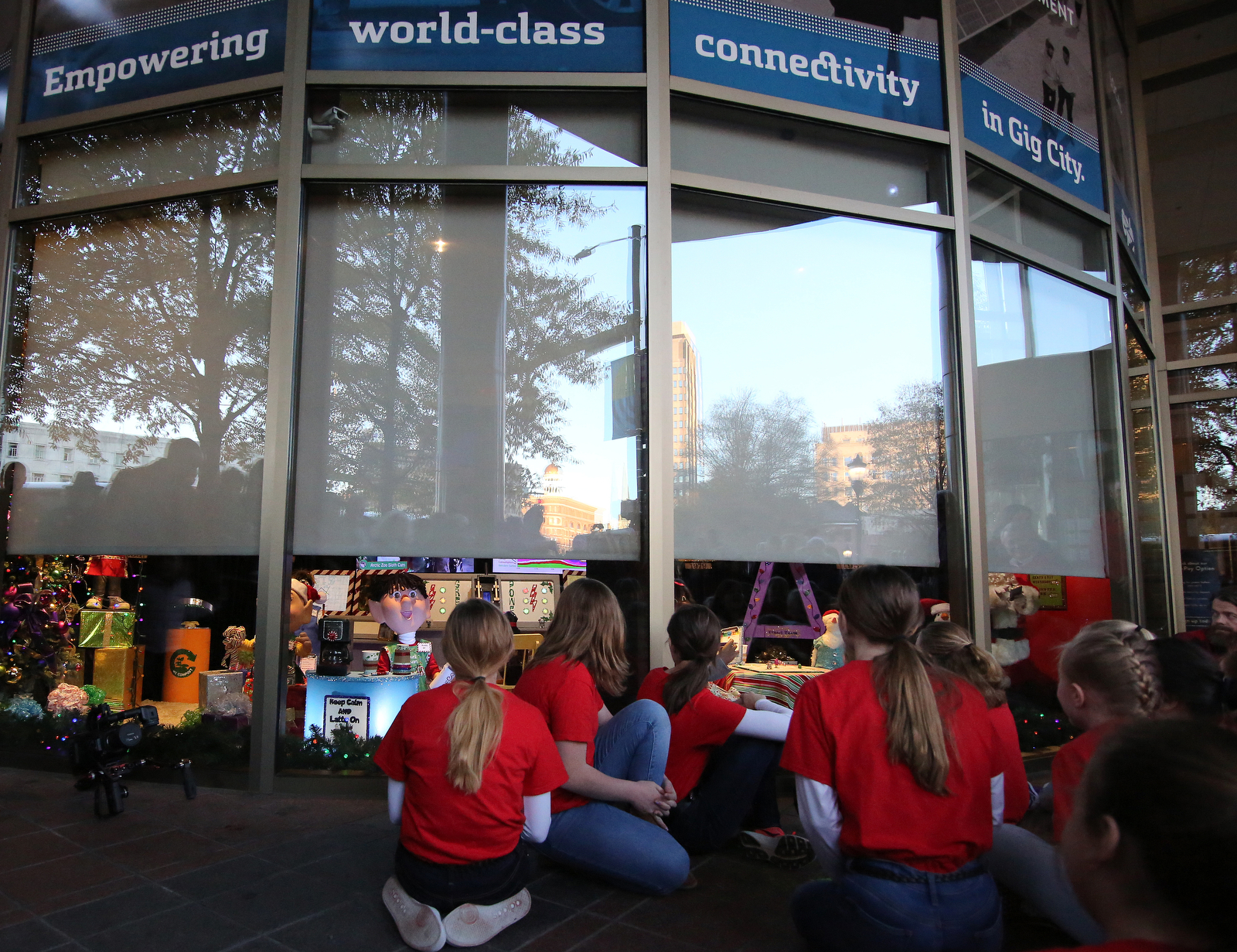 The Chattanooga Girls' Choir watches as the curtain is raised during EPB's traditional Holiday Windows revealing Wednesday, November 21, 2018 in Chattanooga, Tennessee. This year, the windows were designed to represent