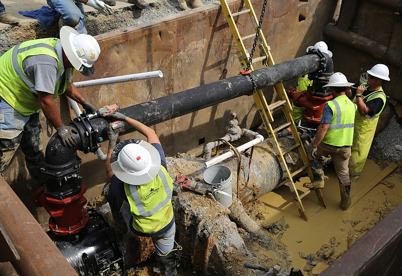 Tennessee American Water workers install a temporary line to bypass a pipe after a water main break last year. The water utility plans to spend more than $20 million in improvements next year to limit such pipe breaks and install a new water basin to improve overall water quality.