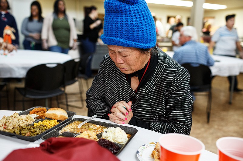 Vonne Porter prays before eating Thanksgiving lunch at the Chattanooga Community Kitchen on Thursday, Nov. 22, 2018, in Chattanooga, Tenn. Dozens of volunteers came to cook and serve the kitchen's annual holiday meal.