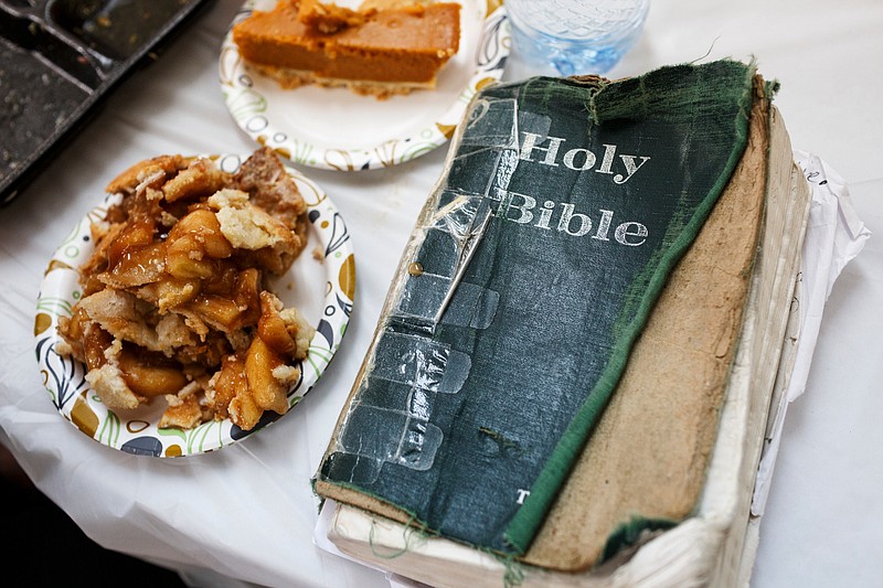 A worn bible sits on a table next to a piece of pie at a Thanksgiving lunch at the Chattanooga Community Kitchen on Thursday, Nov. 22, 2018, in Chattanooga, Tenn. Dozens of volunteers came to cook and serve the kitchen's annual holiday meal.