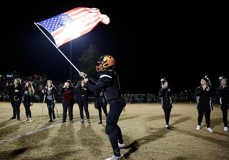 Meigs County player Eli Loden (15) waves an American flag as the team takes the field during the Tigers' TSSAA Class 2A playoff football quarterfinal game against the South Greene Rebels at Meigs County High School on Friday, Nov. 16, 2018, in Decatur, Tenn. 