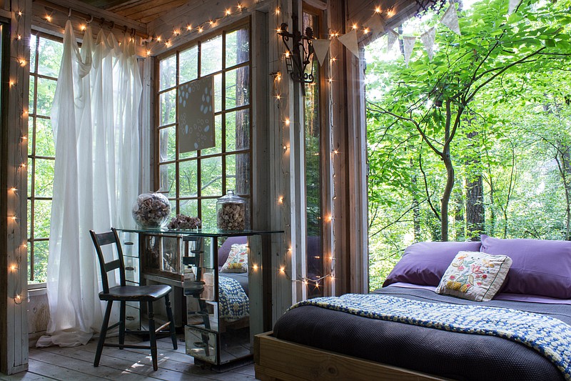 In this Atlanta treehouse, the bed is on wheels and can be rolled onto an outdoor platform that overlooks a stream.