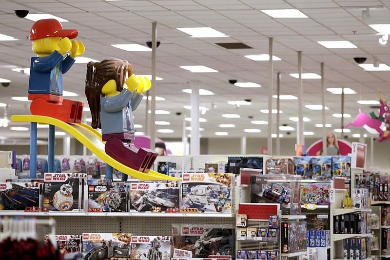 In this Friday, Nov. 16, 2018, file photo photo a display shows two large Lego toys on a slide near the toy section at a Target store in Bridgewater, N.J. Cozy sweaters and soft pajamas are in for adults. Kids, meanwhile, are asking for board games featuring fake poop and pimples. (AP Photo/Julio Cortez, File)