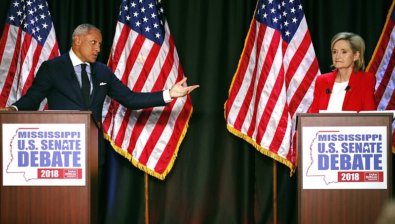 In this Nov. 20, 2018, photo, Democrat Mike Espy, left, challenges a answer from appointed U.S. Sen. Cindy Hyde-Smith, R-Miss., during their televised Mississippi U.S. Senate debate in Jackson, Miss. Hopeful Democrats are eyeing a victory by driving up African American turnout after Hyde-Smith stirred outrage by telling a supporter she'd attend a "public hanging" if he asked. Civil rights groups are trying to motivate black voters, although they don't explicitly support Espy, while Republicans also are focused on turnout. (AP Photo/Rogelio V. Solis, Pool)