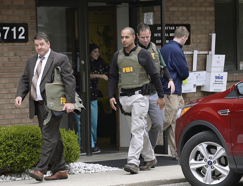 FILE - In this April 21, 2017 file photo, FBI agents leave the office of Dr. Fakhruddin Attar at the Burhani Clinic in Livonia, Mich., after completing a search for documents. A federal judge dismissed some charges Tuesday, Nov. 20, 2018, against eight people, including two doctors, in the genital mutilation of nine girls at the suburban Detroit clinic, finding it's up to states rather than Congress to regulate the practice. (Clarence Tabb Jr. /Detroit News via AP, File)

