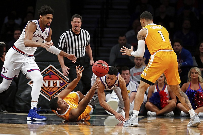 Tennessee forward Grant Williams, on court, passes to teammate Lamonte Turner, right, as Kansas forward Dedric Lawson, left, and guard Devon Dotson go after the ball during the first half of the NIT Season Tip-Off tournament title game Friday night at Barclays Center in Brooklyn, N.Y.