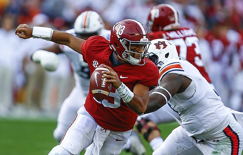 Alabama quarterback Tua Tagovailoa escapes pressure from Auburn defensive lineman Marlon Davidson during the first half of Saturday's game in Tuscaloosa. The Crimson Tide won 52-21 after leading 17-14 at halftime.