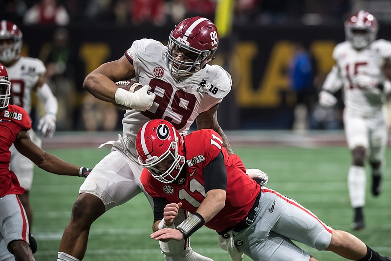 Alabama defensive end Raekwon Davis tries to avoid a hit from Georgia quarterback Jake Fromm during an interception return in the Crimson Tide's 26-23 overtime win over the Bulldogs in January. The same two teams that played for last season's national championship will play this week for the Southeastern Conference title.