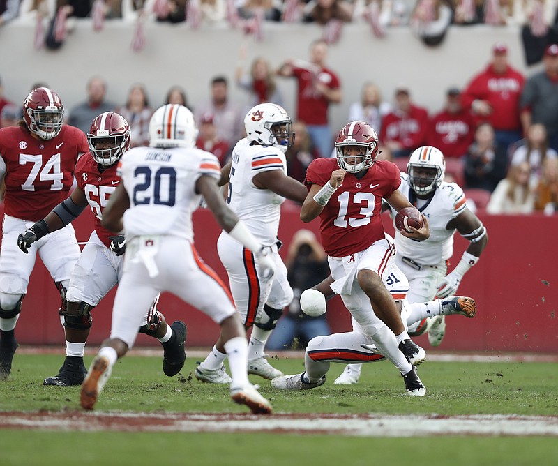 Alabama sophomore quarterback Tua Tagovailoa (13), shown running for a first down during Saturday's home win over Auburn, said his touchdown pass to defeat Georgia in January's national championship game is in the past.