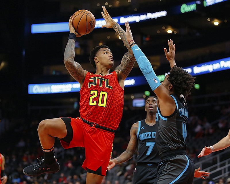 Atlanta Hawks forward John Collins shoots over Charlotte Hornets guard Devonte' Graham during the first half of Sunday night's game in Atlanta.