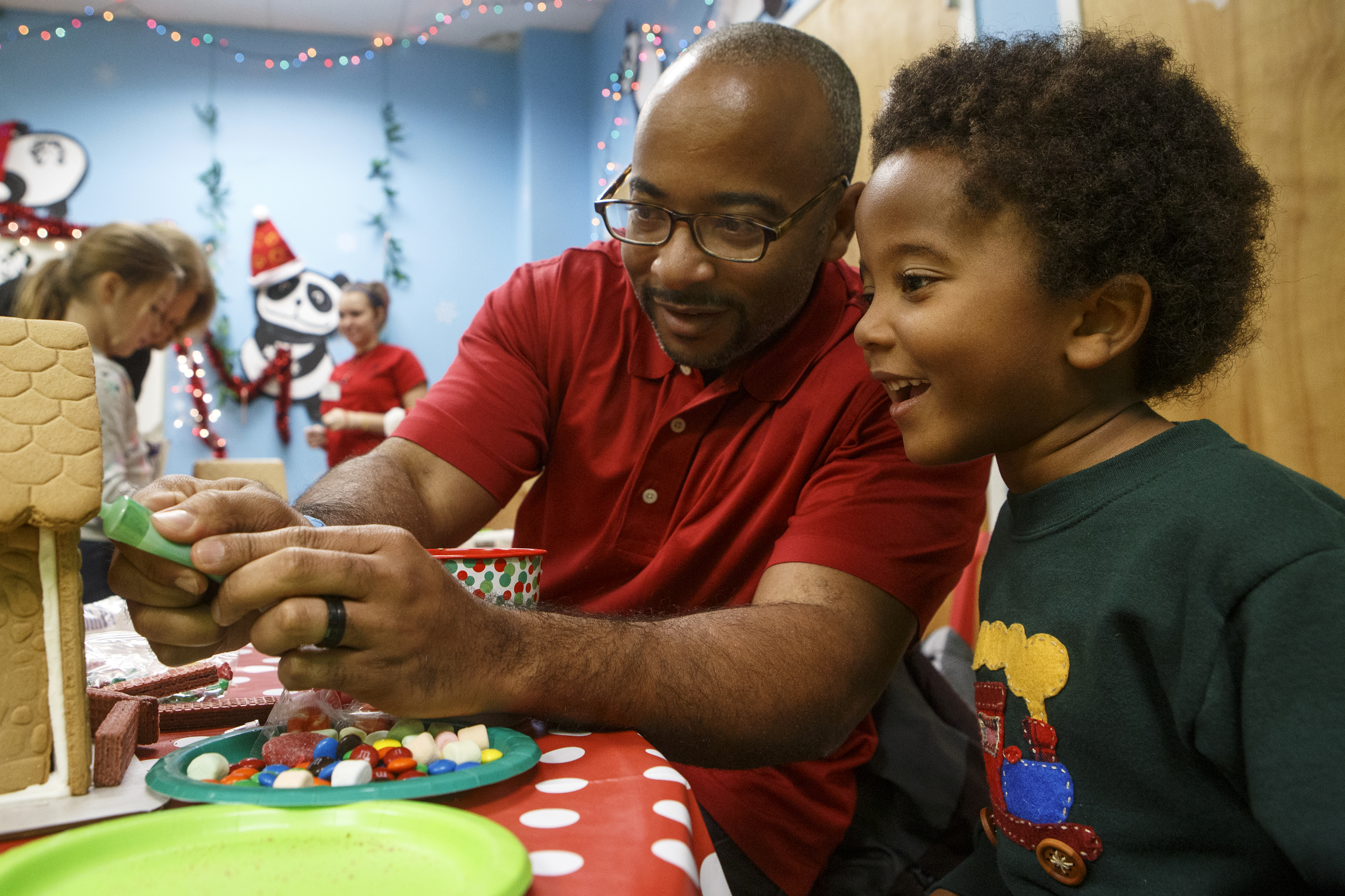Five-year-old Devin Beyah smiles as his dad Raheem puts icing on their gingerbread house during the Gingerbread Workshop at the Creative Discovery Museum on Sunday, Nov. 25, 2018 in Chattanooga, Tenn.