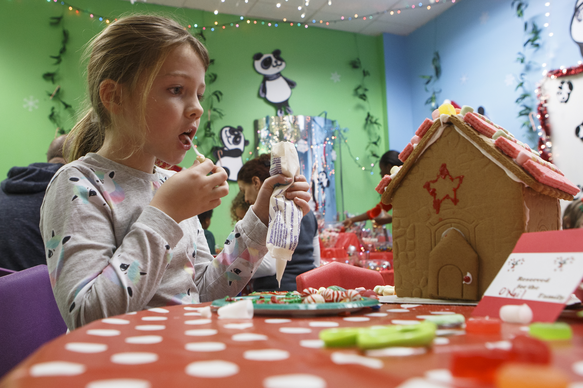 Frankie West, 8, tastes some of the icing while decorating her gingerbread house during the Gingerbread Workshop at the Creative Discovery Museum on Sunday, Nov. 25, 2018 in Chattanooga, Tenn.