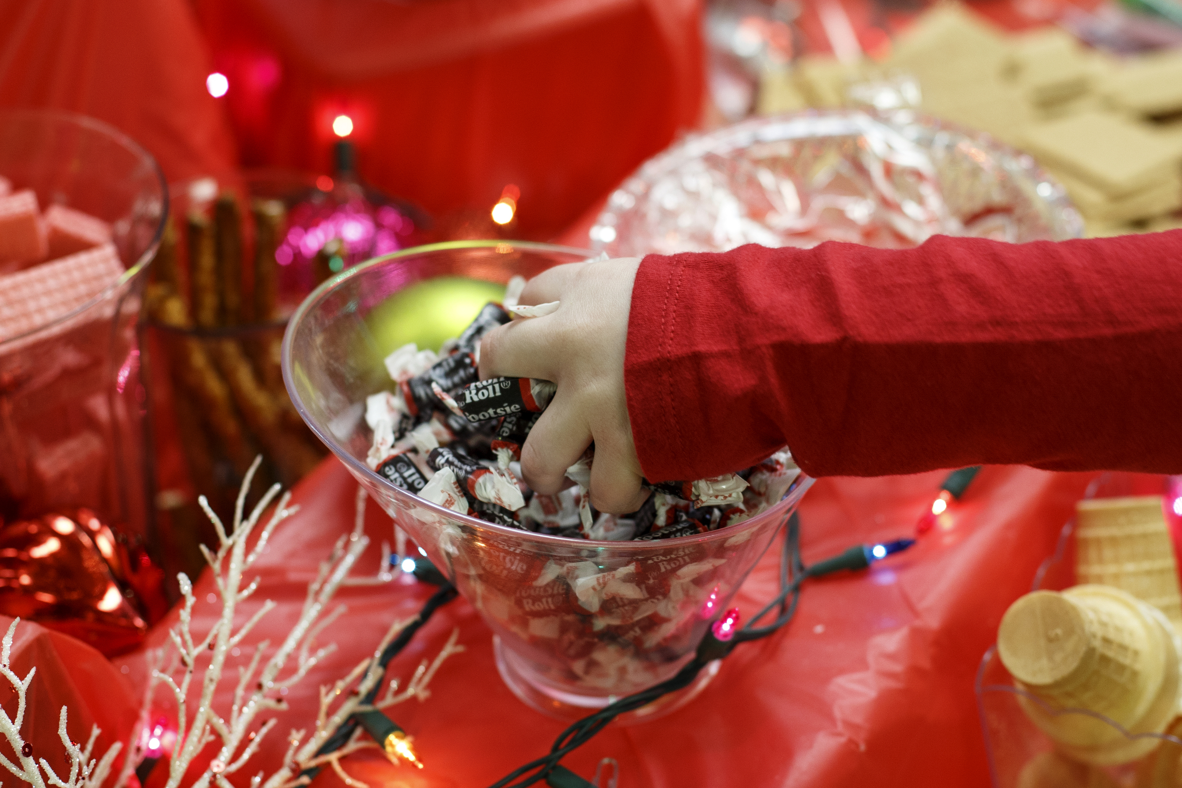 Six-year-old Aria McEntyre grabs some Tootsie Rolls to use in building her gingerbread house during the Gingerbread Workshop at the Creative Discovery Museum on Sunday, Nov. 25, 2018 in Chattanooga, Tenn.