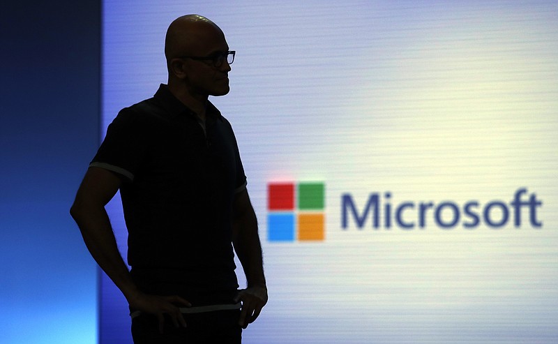FILE- In this May 7, 2018, file photo Microsoft CEO Satya Nadella looks on during a video as he delivers the keynote address at Build, the company's annual conference for software developers in Seattle. Microsoft is threatening to overtake Apple as the world’s most valuable publicly traded company. The market closed Tuesday, Nov. 27, with Microsoft just behind Apple. (AP Photo/Elaine Thompson, File)
