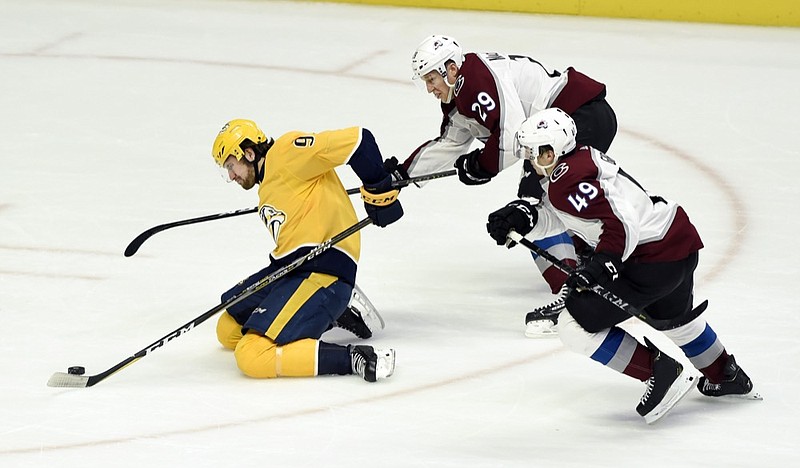 Nashville Predators left wing Filip Forsberg (9), of Sweden, moves the puck in front of Colorado Avalanche center Nathan MacKinnon (29) and defenseman Samuel Girard (49) during the second period of an NHL hockey game, Tuesday, Nov. 27, 2018, in Nashville, Tenn. (AP Photo/Mark Zaleski)

