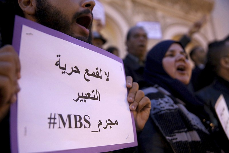 An activist holds up a placard that reads "No to repression of freedom of expression #MBS assassin" on the eve of Saudi Crown Prince Mohammed bin Salman's official visit to Tunisia, during a protest to denounce the killing of Saudi journalist Jamal Khashoggi, in downtown Tunis on Monday. (AP Photo/Hassene Dridi)