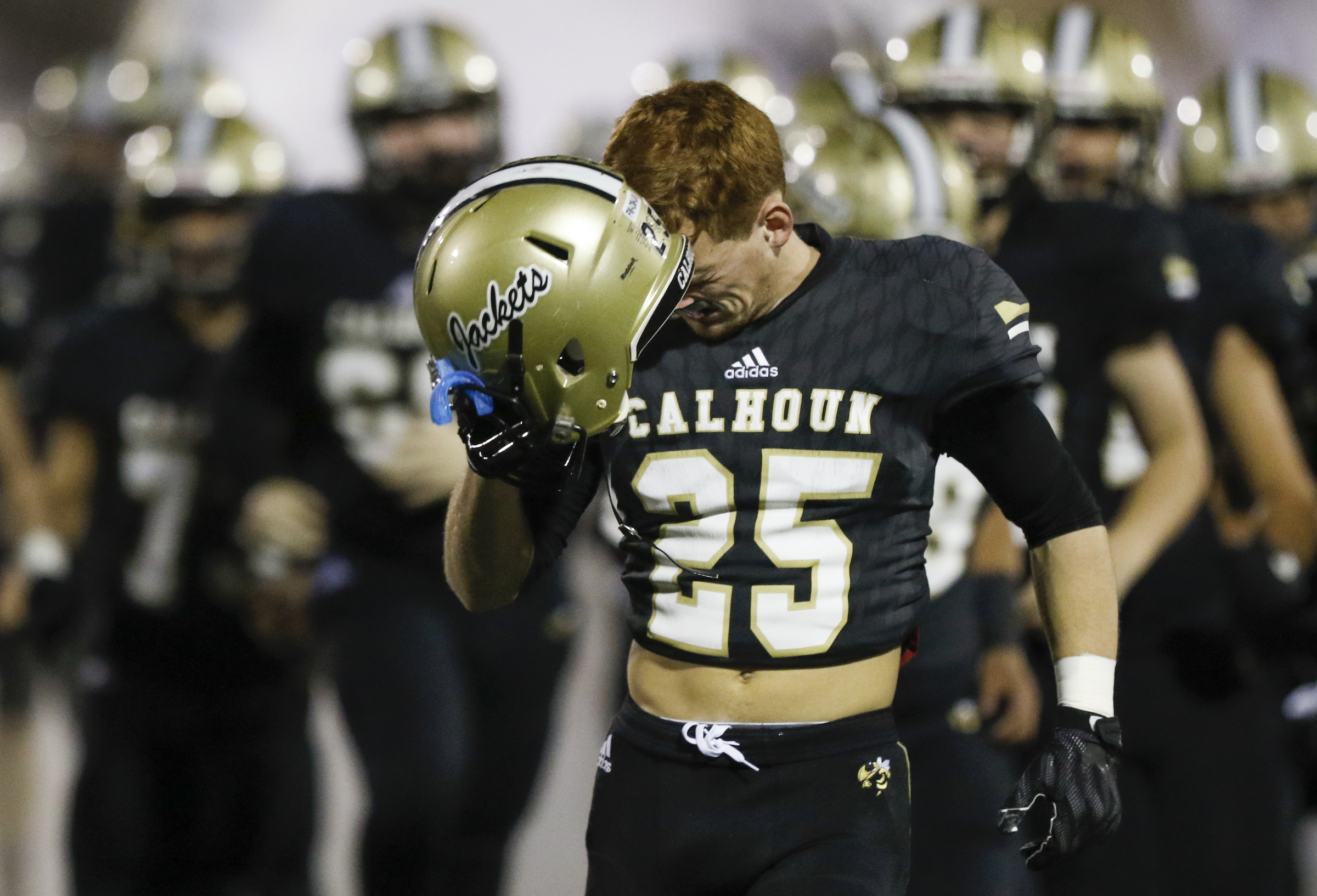 Calhoun's Jeremy Register (25) hits himself in the head with his helmet after running onto the field before their GHSA Class AAA semifinal game against Peach County at Phil Reeve Stadium on Friday, Nov. 30, 2018 in Calhoun, Ga.