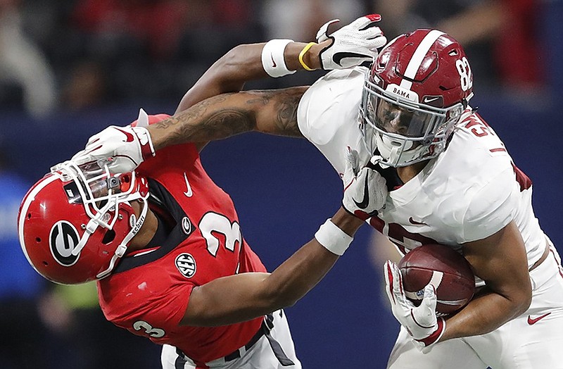 Alabama tight end Irv Smith Jr., right, hits Georgia defensive back Tyson Campbell during the first half of Saturday's SEC championship game at Mercedes-Benz Stadium in Atlanta. Alabama rallied late to beat the Bulldogs 35-28.
