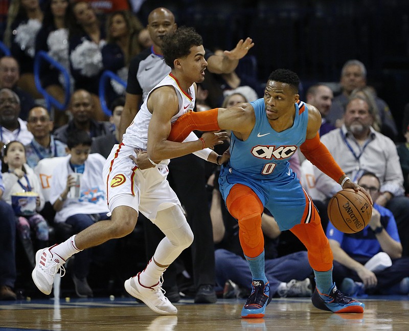 Oklahoma City Thunder star Russell Westbrook dribbles while guarded by Atlanta Hawks rookie Trae Young during Friday night's game in Oklahoma City.