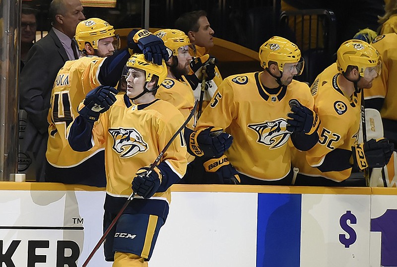 Nashville Predators defenseman Eeli Tolvanen, front left, accepts congratulations after scoring the first goal of his NHL career during Saturday night's 5-2 home win against the Chicago Blackhawks.