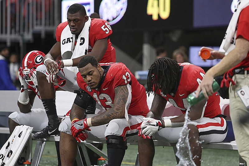 Georgia football players sit on the bench after the Bulldogs lost 35-28 to Alabama in the SEC championship game Saturday at Mercedes-Benz Stadium in Atlanta.