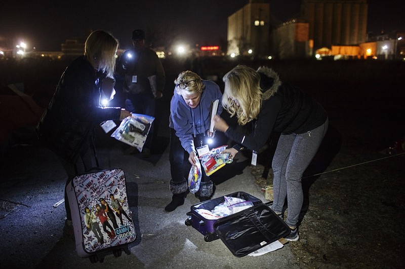 Tammie Carpenter, left, Betsy McCright, center, and Theresa Biggs remove care packages from suitcases to hand out while conducting an annual Point in Time Homeless Count on Thursday, Jan. 25, 2018, in Chattanooga, Tenn. Volunteers conducted surveys of homeless individuals and families in the region to provide data that will help service providers to offer targeted care and outreach.