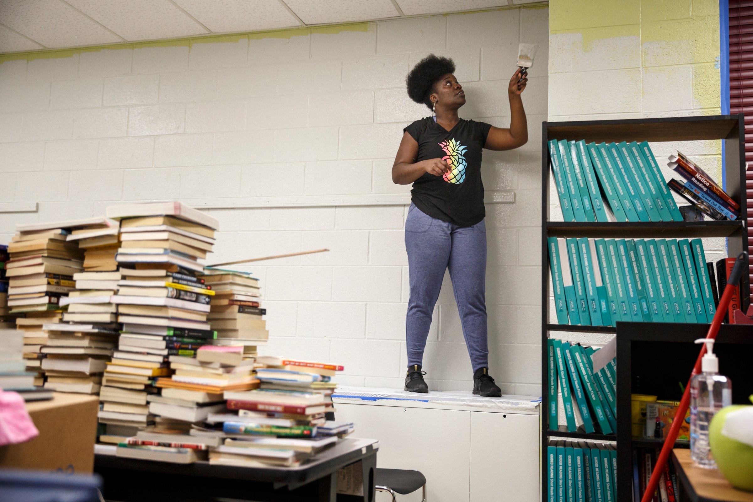 Faith Sims paints a classroom wall.