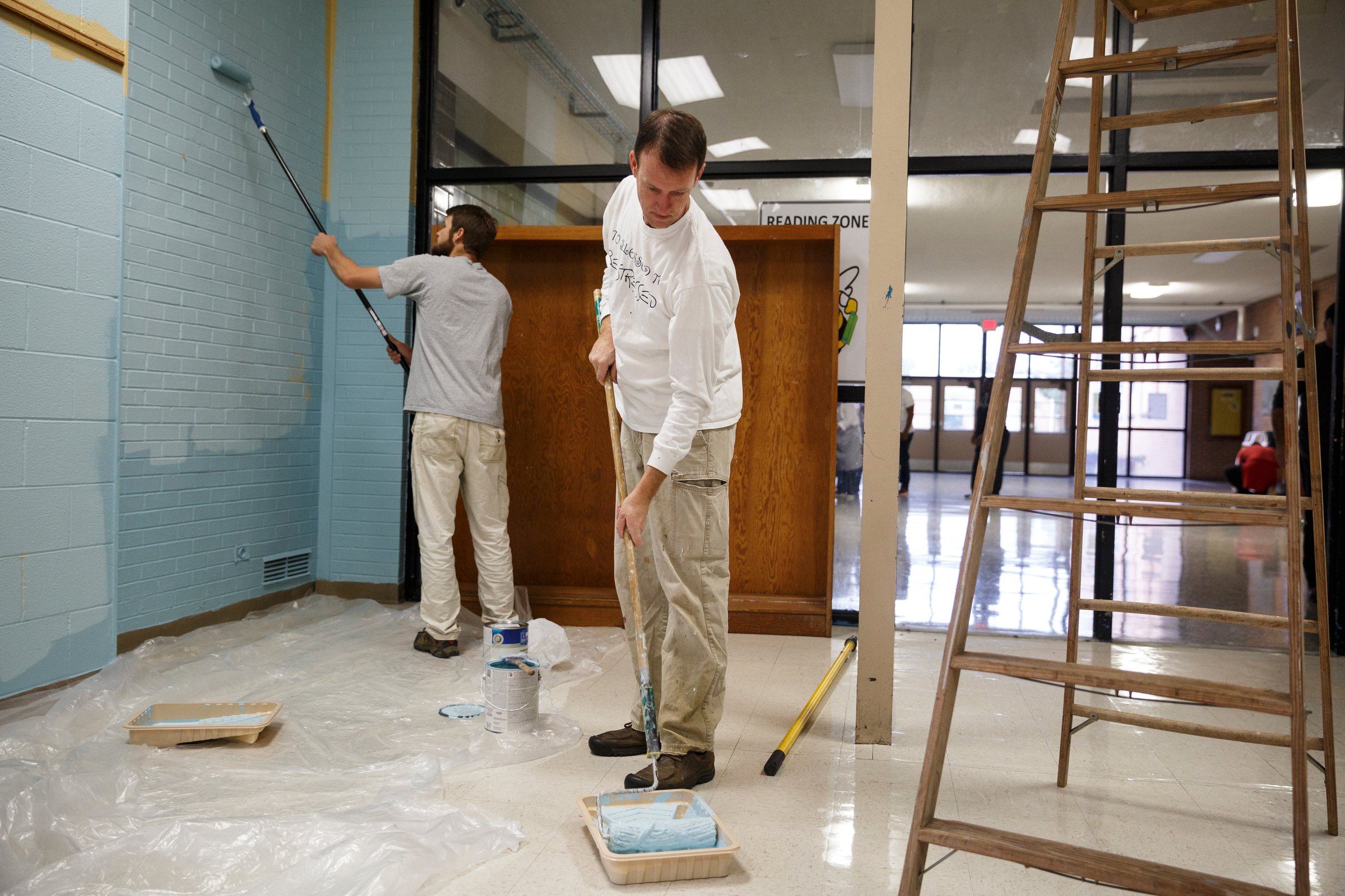 Brent Campbell, right, and Peyton Heard paint a hallway wall.