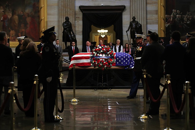 The flag-draped casket of former President George H.W. Bush lies in state in the Capitol Rotunda in Washington on Tuesday. (AP Photo/Manuel Balce Ceneta)