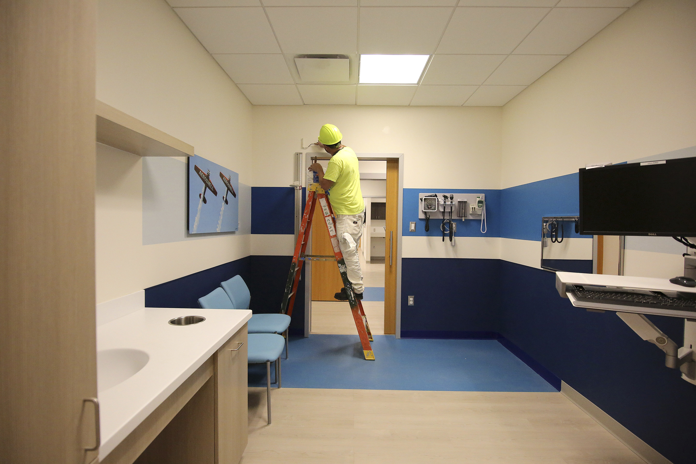 Staff photo by Erin O. Smith / Rigoberto Mendoza with K Building works his way around patient rooms painting areas that need a touchup at Erlanger's new children's outpatient center Wednesday, Nov. 28, 2018, in Chattanooga, Tennessee. Each patient room contains a photograph by a local photographer.
