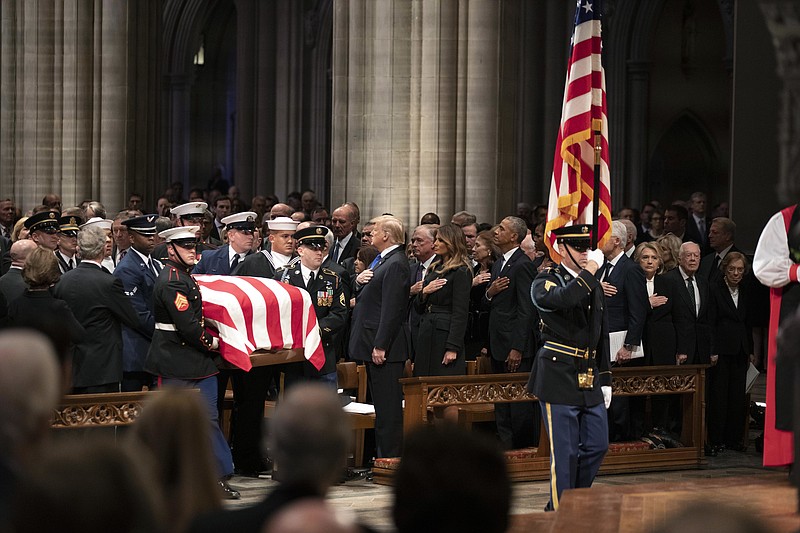 The flag-draped casket of former President George H.W. Bush is carried by a military honor guard past former President George W. Bush, left side, President Donald Trump, first lady Melania Trump, former President Barack Obama, Michelle Obama, former President Bill Clinton, former Secretary of State Hillary Clinton, former President Jimmy Carter, and Rosalynn Carter during a State Funeral at the National Cathedral, Wednesday, Dec. 5, 2018, in Washington. (AP Photo/Alex Brandon, Pool)